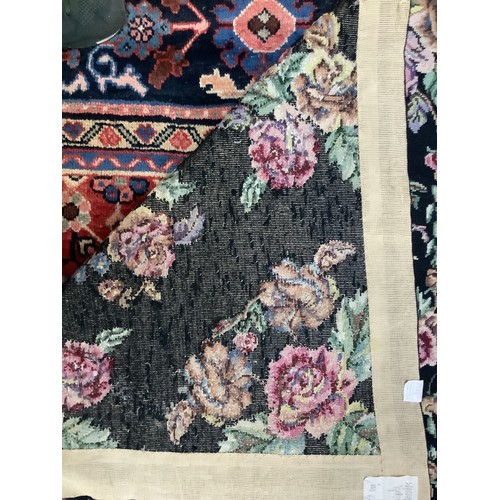 414 - A hand-knotted fatweave floral carpet, worked with a field of roses and trellis to a black ground wi... 