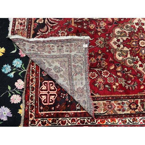 418 - A Persian hand-knotted wool rug, worked with a central stylised floral medallion to a red ground, wi... 