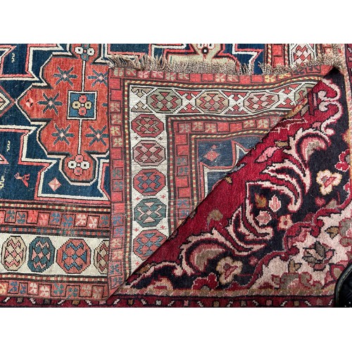 419 - A hand-knotted tribal wool rug of Afshar design, worked with three guls to a blue ground within a be... 