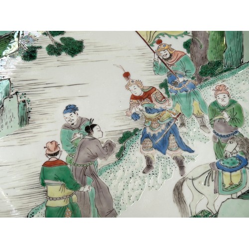 64 - A Chinese Kangxi period porcelain dish, painted in Wucai enamels depicting a scene with six figures ... 