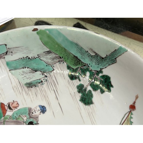 64 - A Chinese Kangxi period porcelain dish, painted in Wucai enamels depicting a scene with six figures ... 