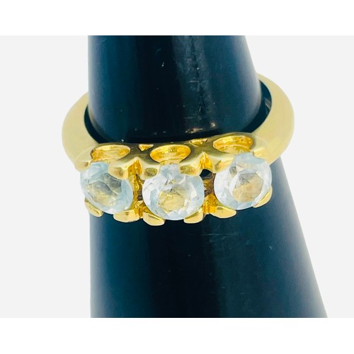 147 - An 18ct yellow gold dress ring, set with three pale blue faceted stones in a claw setting, ring weig... 