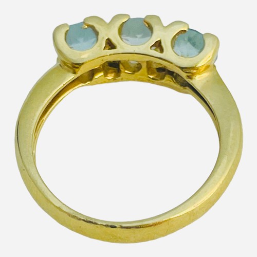 147 - An 18ct yellow gold dress ring, set with three pale blue faceted stones in a claw setting, ring weig... 