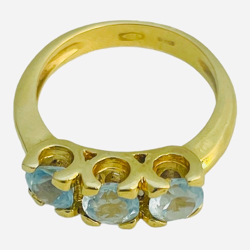 147 - An 18ct yellow gold dress ring, set with three pale blue faceted stones in a claw setting, ring weig... 