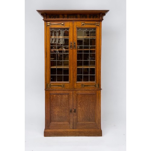 536 - An early 20th century oak bookcase in in Arts and Crafts style, the frieze with applied black letter... 