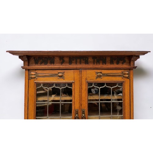 536 - An early 20th century oak bookcase in in Arts and Crafts style, the frieze with applied black letter... 