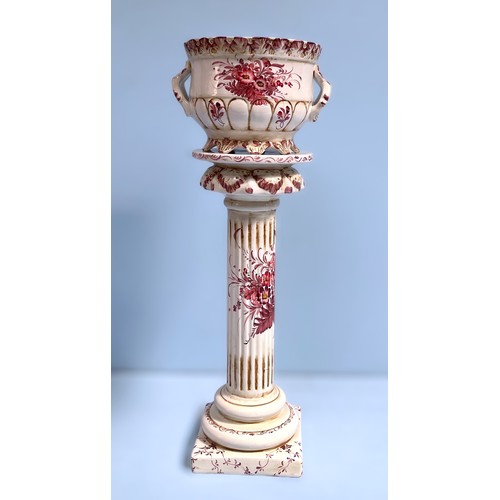 30 - A Portugese pottery jardiniere on columns stand, decorated with pink flowers, 83cm