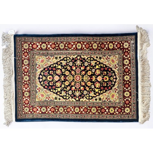 407 - A hand-knotted Persian silk rug, finely work in multi-coloured silk with central floral  blue ground... 