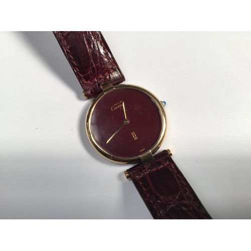 130 - A ladies Must De Cartier quartz wristwatch, the plain dark rouge dial with gilt branding, housed in ... 