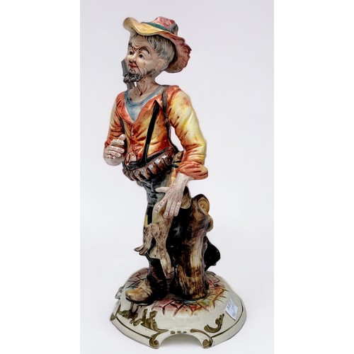 37 - A Capodimonte figure of a huntsman with rabbit walking by a tree stump, with factory marks to base, ... 