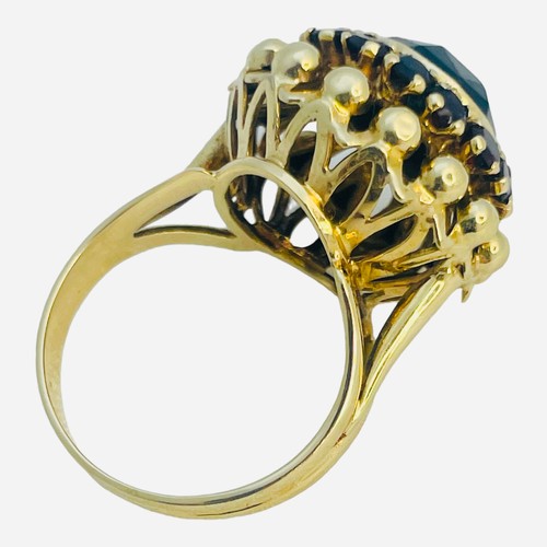 145 - An 14ct yellow gold dress ring, set with a round faceted garnet to the centre, with 14 x small round... 