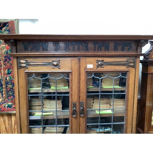 536 - An early 20th century oak bookcase in in Arts and Crafts style, the frieze with applied black letter... 