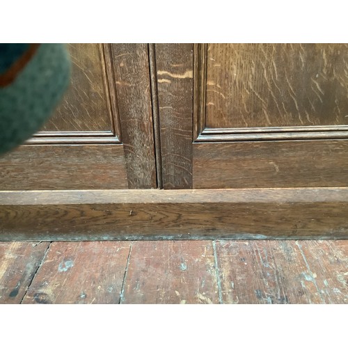 536 - An early 20th century oak bookcase in in Arts and Crafts style, the frieze with applied black letter... 