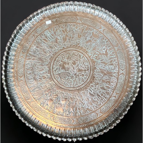 295 - A Persian/Ottoman circular tray-top table, the large dished circular copper top hand-embossed and ch... 