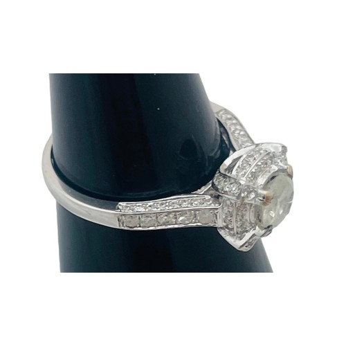 246 - A 14ct white gold ring, set with a round brilliant cut cloudy diamond, with further diamonds surroun... 