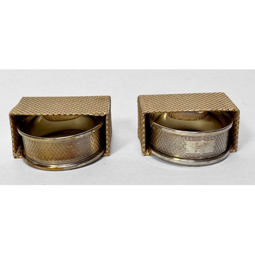 116 - A pair of silver napkin rings with engined-turned decoration and original boxes, together and a pier... 