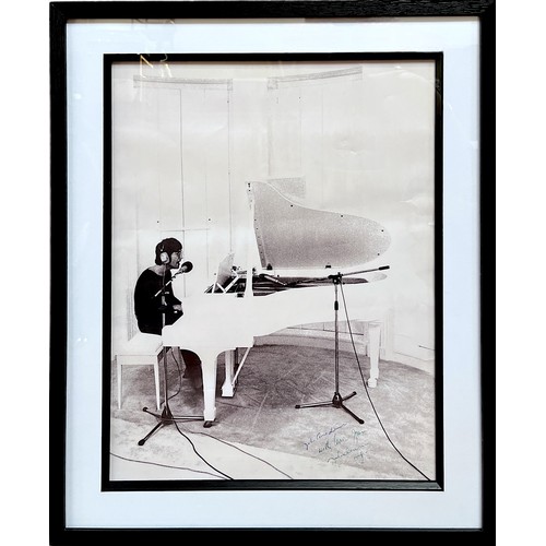 315 - A black and white image of John Lennon performing at his iconic white grand piano, signed to bottom ... 