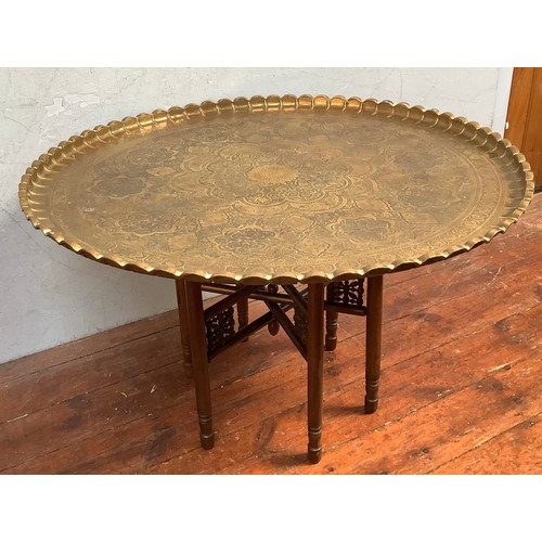 547 - A large Indian circular brass tray top table, decorated with floral designs and birds, with crimped ... 