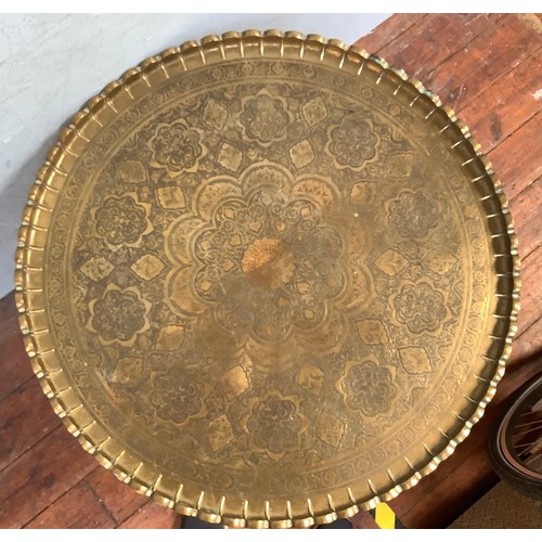 547 - A large Indian circular brass tray top table, decorated with floral designs and birds, with crimped ... 