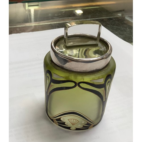 117 - A silver-mounted cylindrical green-tinted glass dressing table jar with Art Nouveau enamel and gilt ... 