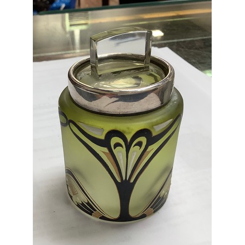 117 - A silver-mounted cylindrical green-tinted glass dressing table jar with Art Nouveau enamel and gilt ... 