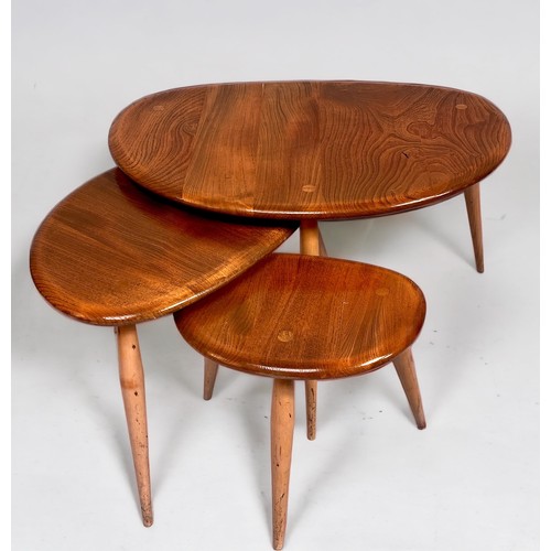 565 - A nest of three blonde elm Ercol pebble tables, raised on splayed and turned beech supports, largest... 