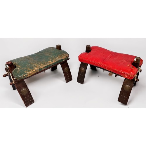 564 - Two various Egyptian Camel stools with wooden frames and leather cushion (one red, one green)