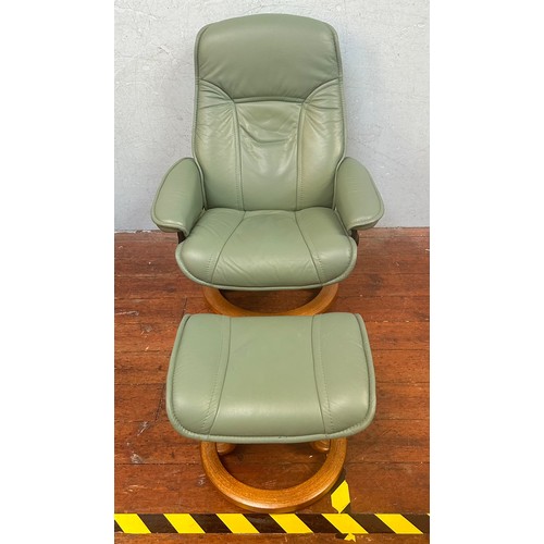 354 - A matched pair of green leather swivel and reclining armchairs, each with footstools