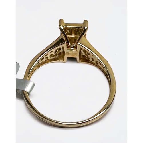 158 - A 10ct yellow gold dress ring, invisible set with six green square shaped sapphires, flanked by 12 x... 