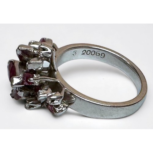 175 - An 18ct white gold dress ring, claw set with 9 x marquise-cut rubies, 2 x emerald-cut rubies, and 6 ... 