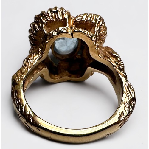 192 - A 9ct gold dress ring, of stylised floral design, set with an oval faceted blue stone to the centre,... 