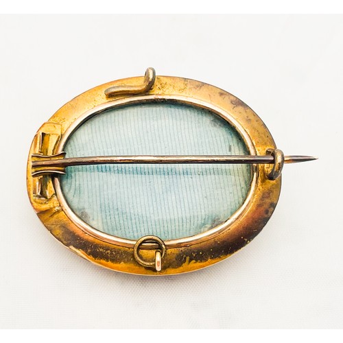 206 - A Victorian Etruscan Revival gold mourning brooch, glass backed with pin fastening.