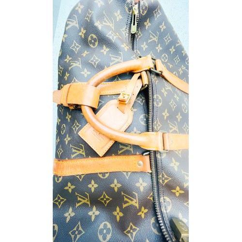 263 - A Louis Vuitton monogram holdall, 40, with tan leather luggage tag, brass hardware, zip broken.