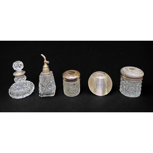 34 - A collection of silver and silver-plate topped and collared toilette bottles and jars, comprising cu... 