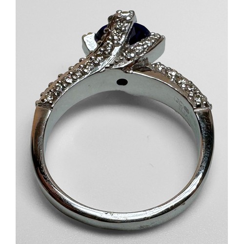 68 - An 18ct white gold dress ring, set with a round faceted tanzanite to the centre, with 3 x rows of pa... 