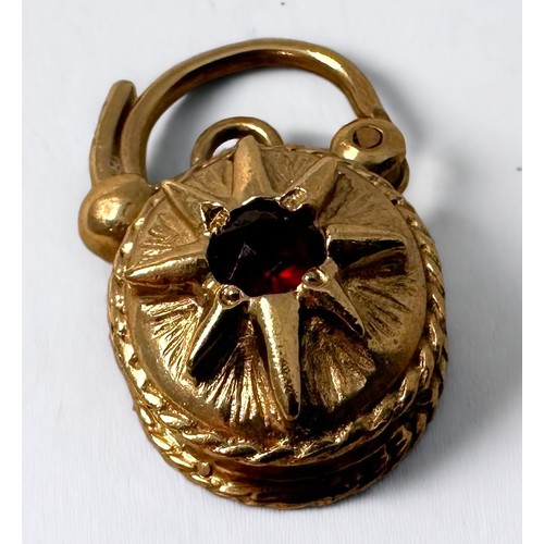 85 - A 9ct yellow gold padlock, set with a faceted garnet to the front, and a smaller garnet to the back,... 