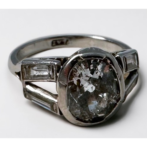 109 - A platinum and diamond ring, rub-over set with an oval-shaped Victorian cut diamond to the centre, e... 