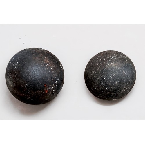 523 - Two antique heavy iron cannon balls, one 6-inch and one 5-inch, (2)