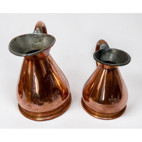 521 - A harlequin set of three graduated copper haystack jugs, the largest measuring 1/2 gallon, including... 