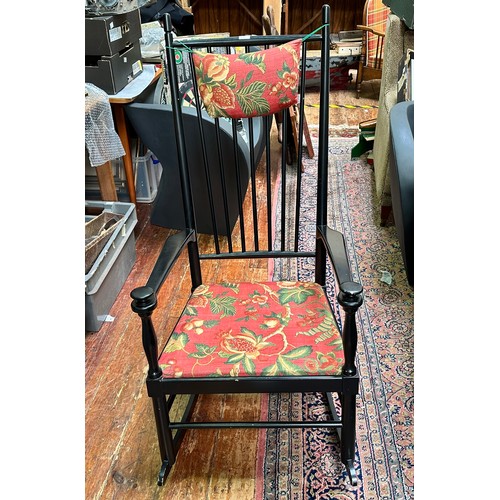 299 - A stained black stick-back rocking chair, with red floral upholstered drop-in seat and turned finial... 