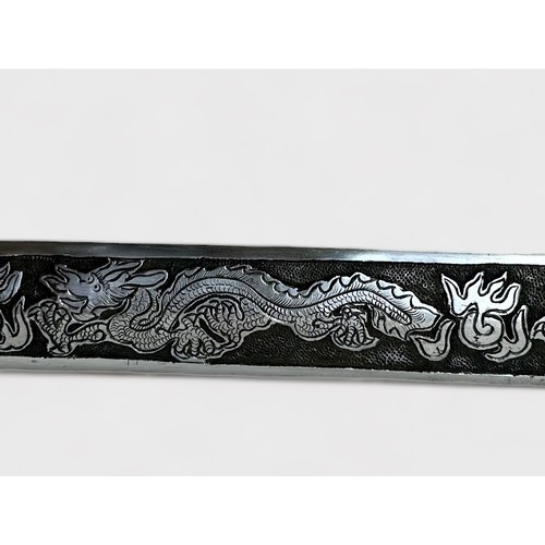 522 - A Chinese heavy Sword (Jian), the 31-inch double-edged steel blade with panels of dragons in relief,... 