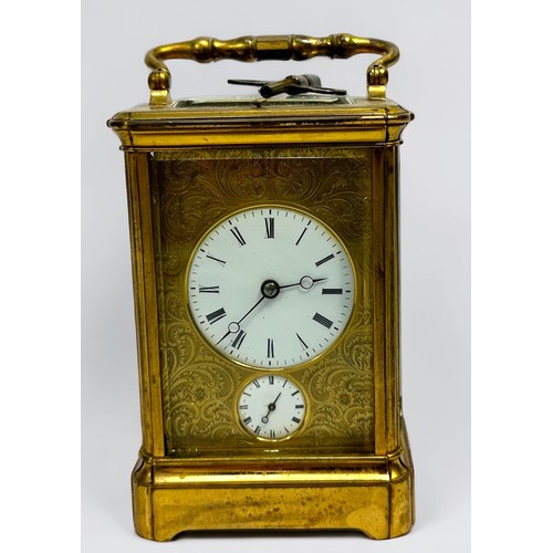 389 - A 19th century brass repeating carriage alarm clock, 8-day movement striking a bell, finely foliate-... 