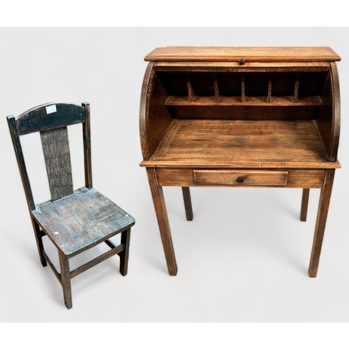 516 - An early 20th century stained oak child's roll-top desk, with enclosed pigeonholes, short frieze dra... 