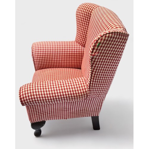 518 - A Child's wingback armchair with red check upholstery, on carbiole supports (a/f)