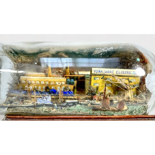 425 - A superb diorama ship-in-a-bottle, with six various sailing barges, freighters and tugs etc, against... 