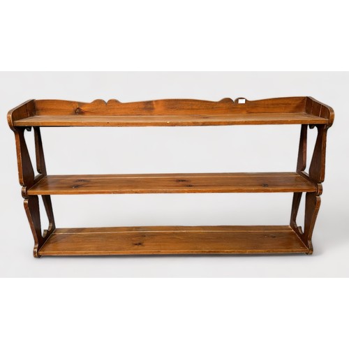 543 - A set of waxed pine hanging open shelves, with fret-cut shaped and pierced ends, shaped pendiment an... 