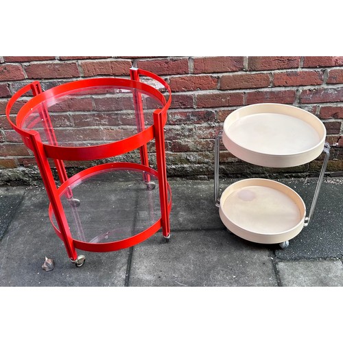 524 - A 1970s/80s red metal circular two-tier drinks trolly with glass top and undertier, 58cm diam, toget... 