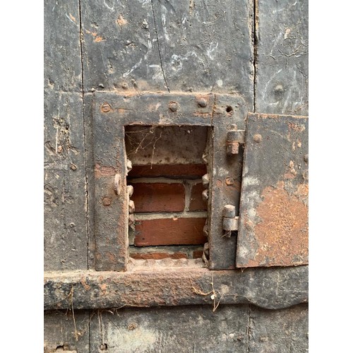 515 - An extremely heavy Medieval Oak lancet-shape castle door, of plank and ledge construction with origi... 