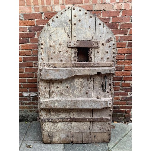 515 - An extremely heavy Medieval Oak lancet-shape castle door, of plank and ledge construction with origi... 