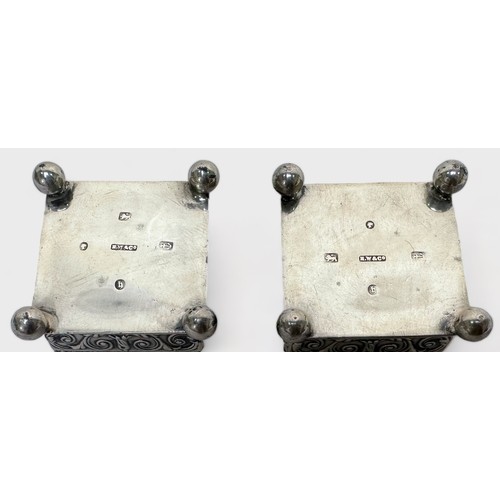 89 - A pair of Victorian silver open table salts, of square form with embossed Arabesque decoration on ba... 